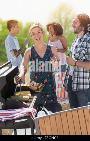 Woman serving hot dogs at barbecue Stock Photo