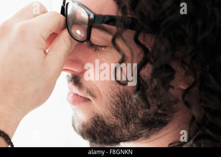 Stressed Caucasian man rubbing his eyes Stock Photo