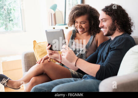 Couple using digital tablet on sofa Stock Photo