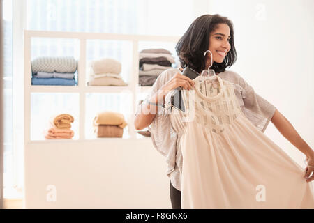 Hispanic woman admiring clothing in store Stock Photo