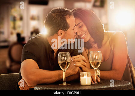 Hispanic couple holding hands at restaurant Stock Photo
