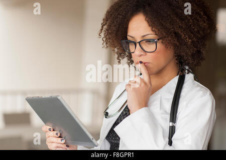 Mixed race businesswoman using digital tablet in office Stock Photo