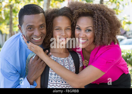 Smiling family hugging outdoors Stock Photo