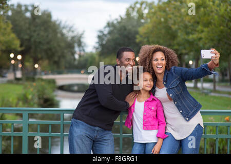 Family taking selfie on bridge Stock Photo