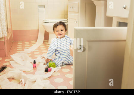 Baby boy playing in messy bathroom Stock Photo
