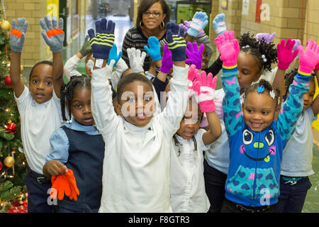Detroit, Michigan USA. 9th December 2015. Children at Dossin Elementary School show off the mittens they have just received mittens from a charity called Mittens for Detroit. The charity is distributing mittens to 26,000 Detroit Public Schools elementary students; most were donated by employees of Fiat Chrysler Automobiles. Credit:  Jim West/Alamy Live News Stock Photo