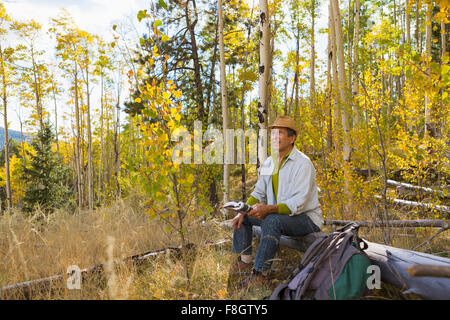 Man sitting in autumn forest Stock Photo