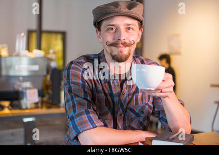 Caucasian man drinking coffee in cafe Stock Photo