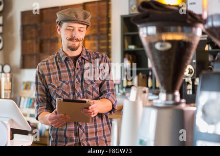 Caucasian man using digital tablet in cafe Stock Photo