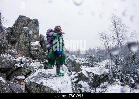 Caucasian hiker standing on rocky hillside Stock Photo