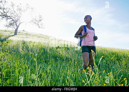 Black woman walking on rural hillside Stock Photo