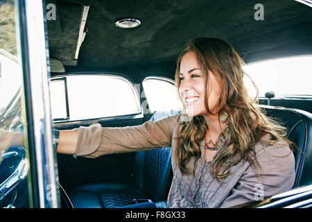 Mixed race woman driving vintage car Stock Photo