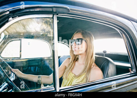 Caucasian woman driving vintage car Stock Photo