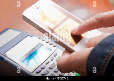 Hispanic woman paying with cell phone Stock Photo