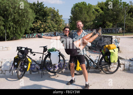 Man carrying girlfriend on bicycle journey Stock Photo