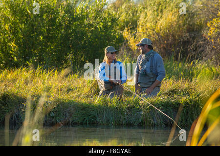 Caucasian couple fishing in river Stock Photo