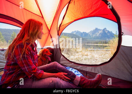 Caucasian woman and dog in camping tent Stock Photo