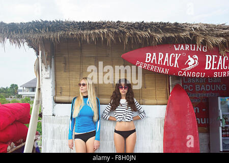 Caucasian women standing at surf hut on beach Stock Photo