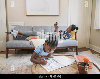 African American mother and daughter relaxing in living room Stock Photo