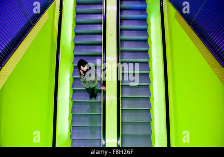 Japanese woman riding escalator Stock Photo