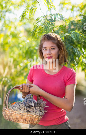 Mixed race woman carrying basket of flowers Stock Photo