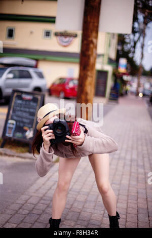 Caucasian woman photographing outdoors Stock Photo