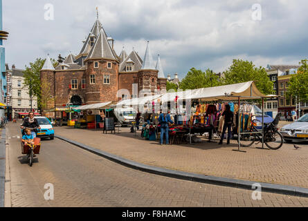 Market stall and street with lady on bicycle with child in city of Amsterdam Holland Stock Photo