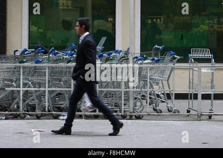 Sao Paulo, Brazil. 9th Dec, 2015. A resident walks past shopping carts, in Sao Paulo, Brazil, Dec. 9, 2015. The inflationary value in Brazil increased 10.49 percent in the las 12 months, after raising 1.01 percent in last year's November, informed on Wednesday the State Brazilian Institute of Geography and Statistics (IBGE, for its acronym in Spanish). The inflation added 9.62 percent in the last 11 months in the South American country, and turned the highest rank for a similar period since 2002. © Rahel Patrasso/Xinhua/Alamy Live News Stock Photo