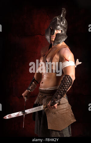 Gladiator posing isolated in a dark background Stock Photo - Alamy