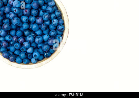 Wooden bowl of picked blueberries from above and isolated on white background Stock Photo