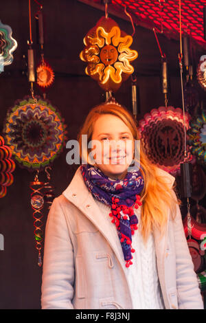 Stall holder with colourful moving decorations for sale at Christmas market stall in Southbank, London UK in December Stock Photo