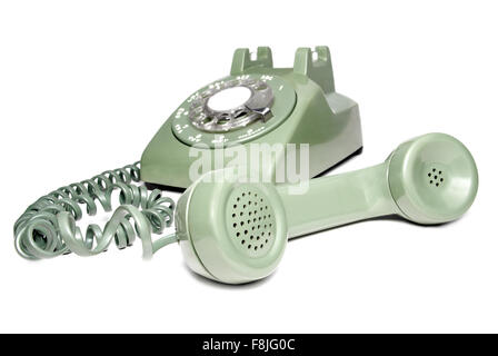 Antique green rotary telephone with receiver off the hook isolated cut out on a white background. Stock Photo