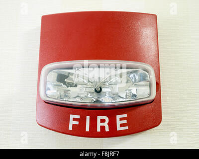 Red fire alarm strobe light smoke detector mounted on a wall as part of a commercial fire protection system Stock Photo