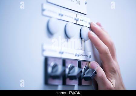 Cropped view of young mans hand adjusting dial on switchgear Stock Photo