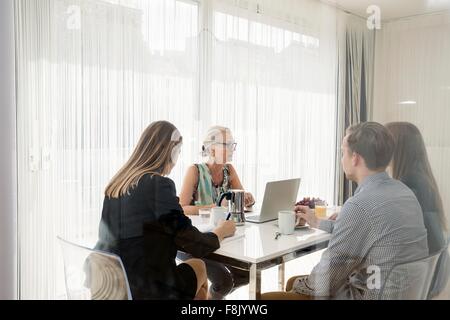 View through window of colleagues sitting at table having business breakfast meeting Stock Photo