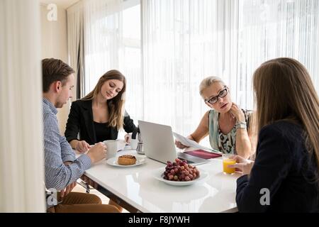 Colleagues sitting at table having business breakfast meeting Stock Photo