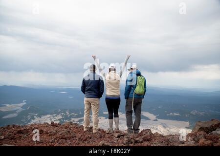Three friends standing at the summit of South Sister volcano, looking at view, Bend, Oregon, USA Stock Photo