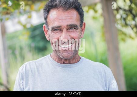 Portrait of mature man with stubble looking at camera smiling Stock Photo