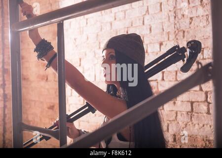 Young female photographer preparing scaffolding in old industrial building Stock Photo