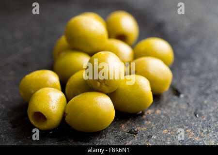 pitted green olives on black table Stock Photo