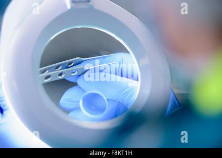 Worker inspecting surgical instruments in clean room of surgical instruments factory, close up Stock Photo