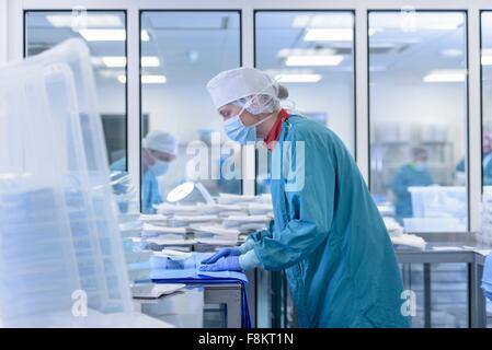 Worker inspecting surgical instruments in clean room of surgical instruments factory Stock Photo