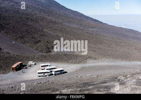 Landscape from one of the main crater on top of Mount Etna, a wooden house and the guide jeeps for tourists in the background. Stock Photo
