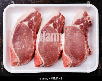 Raw fresh uncooked Pork meat chop steak on bone in white container packaging tray Stock Photo