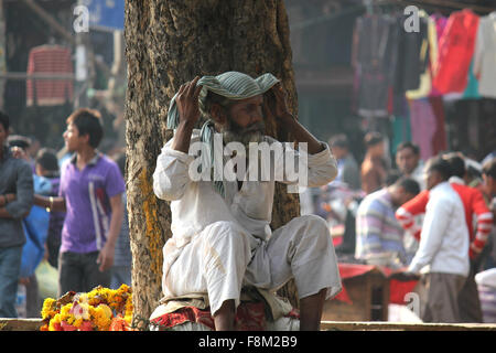 DELHI, INDIA - NOV 25: Indian Man selling flowers in the street on the background of the Delhi market. Image taken on November 2 Stock Photo