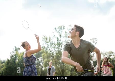 Group of young adults playing badminton in field Stock Photo