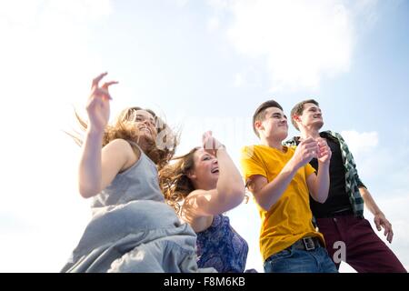 Group of young adults, running, outdoors, low angle view Stock Photo