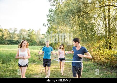 Group of friends in field, using hula hoops Stock Photo