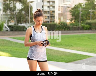 Young woman holding wrist weight in park Stock Photo