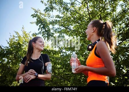 Two young female runners chatting in park Stock Photo